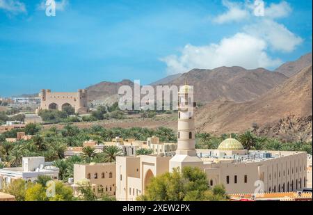 Vue des murs du fort de Bahla à la mosquée et aux portes de la ville avec des montagnes en arrière-plan, Bahla, Oman Banque D'Images