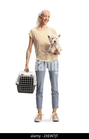 Jeune femme tenant un transporteur pour animaux de compagnie et un chien westie terrier isolé sur fond blanc Banque D'Images