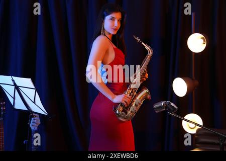 Belle femme avec saxophone sur scène Banque D'Images