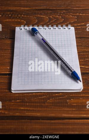 cahier de bureau et stylo sur une table marron Banque D'Images