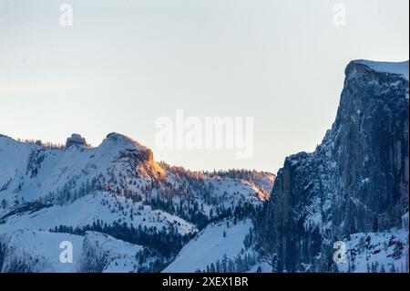 Tôt le soleil attrape les sommets enneigés des sommets de la Sierra nevada dans le parc national de Yosemite, autour du lever du soleil un matin d'hiver tôt. Banque D'Images