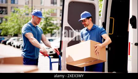 Relocalisation efficace de l'approvisionnement d'entrepôt par des hommes de livraison souriants : la logistique de la chaîne d'affaires en action avec le déchargement de la cargaison du camion Banque D'Images