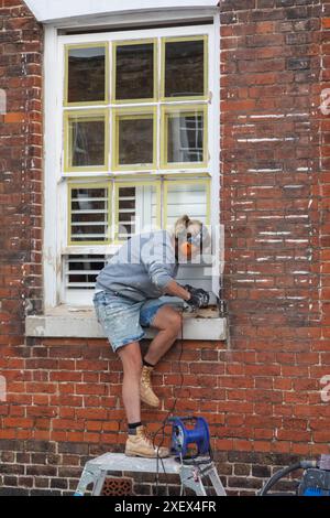 Angleterre, Kent, Sandwich, femme bâtisseur au travail de restauration du bâtiment historique Banque D'Images