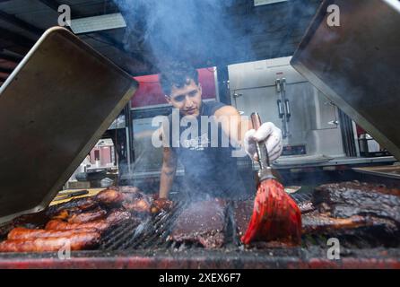 Toronto, Canada. 29 juin 2024. Un chef brosse les côtes avec une sauce barbecue lors du Toronto Ribfest à Toronto, Canada, le 29 juin 2024. L'événement se tient ici du 28 juin au 1er juillet. Crédit : Zou Zheng/Xinhua/Alamy Live News Banque D'Images