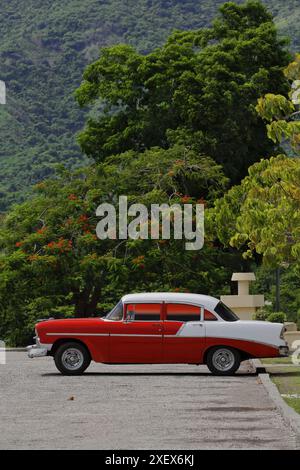 Vue latérale 443, voiture classique américaine rouge avec toit blanc -AD 1956 Chevrolet- stationnée dans le parking El Cobre-Basilique notre Dame de Charité. Santiago-Cuba Banque D'Images