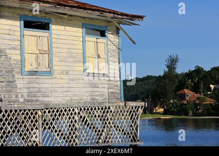 459 Maison en bois vernaculaire de planches de bois avec porche sur pilotis au-dessus de l'eau et toit en tôle, communauté de pêcheurs Cayo Granma Key. Santiago-Cuba. Banque D'Images