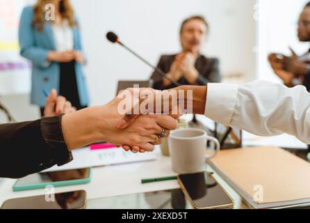 Gros plan d'une poignée de main entre deux femmes d'affaires d'ethnies différentes. Femmes professionnelles concluant un accord dans un environnement de bureau. Équipe diversifiée c Banque D'Images