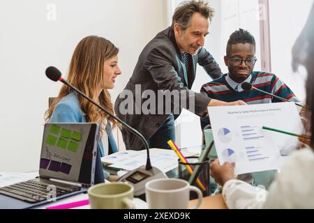 Équipe commerciale diversifiée analysant le rendement et discutant des rapports financiers. Professionnels collaborant sur la stratégie lors d'une réunion d'entreprise. Travail d'équipe Banque D'Images