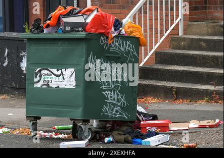 Selly Oak, Birmingham, le 30 juin 2024 - Un canot orange dégonflé est jeté dans un bac de conseil débordant. - Les rues résidentielles de Birmingham ont été transformées en décharges car les étudiants déménagent à la fin de leurs contrats. La plupart des étudiants fréquentent l'Université de Birmingham qui est à environ 800 mètres des rues résidentielles en terrasses Selly Oak. Les routes ont principalement été achetées par les propriétaires qui les louent aux étudiants de premier cycle avec rangée sur rangée de panneaux «pour louer». Crédit : arrêtez Press Media/Alamy Live News Banque D'Images