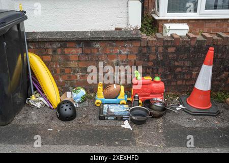 Selly Oak, Birmingham, le 30 juin 2024 - les essentiels pour étudiants sont jetés, y compris une banane gonflable, un cône de circulation et des pots et des casseroles. - Les rues résidentielles de Birmingham ont été transformées en décharges car les étudiants déménagent à la fin de leurs contrats. La plupart des étudiants fréquentent l'Université de Birmingham qui est à environ 800 mètres des rues résidentielles en terrasses Selly Oak. Les routes ont principalement été achetées par les propriétaires qui les louent aux étudiants de premier cycle avec rangée sur rangée de panneaux «pour louer». Crédit : arrêtez Press Media/Alamy Live News Banque D'Images