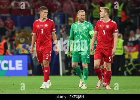 Dortmund, Allemagne. 30 juin 2024. Football, UEFA Euro 2024, Championnat d'Europe, Allemagne - Danemark, finale, manche 16, stade Dortmund, le gardien danois Kasper Schmeichel (M) s'entretient avec Rasmus Höjlund (R) et Jannik Vestergaard lors d'une brève interruption du match. Un homme a grimpé sous le toit du stade pendant le match de championnat d'Europe à Dortmund. Crédit : Christian Charisius/dpa/Alamy Live News Banque D'Images