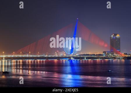 Vue de nuit de l'énorme grande roue et le pont Nguyen Van Troi - Tran Thi Ly sur la rivière Han à Da Nang (Danang), Vietnam. Paysage urbain pittoresque. Banque D'Images