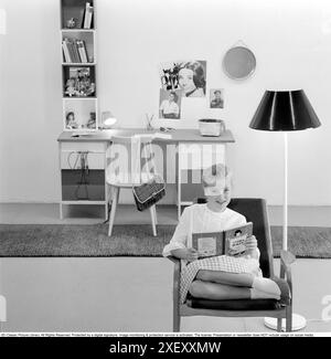 Dans les années 1960 Une adolescente dans sa chambre typique des années 1960, un bureau et ses affaires avec des photos de ses idoles du mur Audrey Hepburn et Elvis Presley. Suède 1960 Banque D'Images