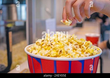 l'enfant goûte le pop-corn classique avant de regarder un film. Journée en famille Banque D'Images