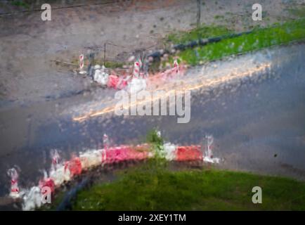 Plan des traînées de lumière des voitures sur la route, fait à travers la fenêtre pendant la pluie Banque D'Images