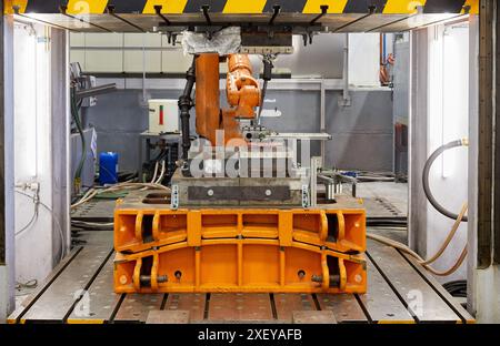 Robot qui introduit les matériaux dans le four et les amène plus tard à la presse, cellule d'estampage à chaud, unité industrielle, industrie automobile, technologie Centr Banque D'Images