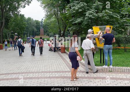 Kiev, Ukraine - 18 août 2018 : les citoyens utilisent les services d'une boîte d'échange de livres de rue. Monument Shevchenko en arrière-plan Banque D'Images