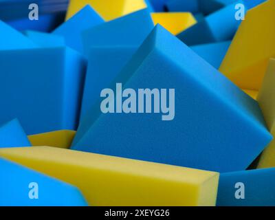 Une grande collection de blocs de mousse dans différentes nuances de bleu et de jaune Banque D'Images