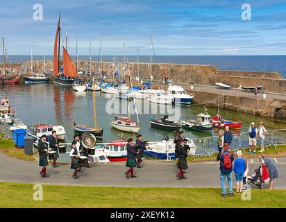 Portsoy Boat Festival The Pipe Band en face du port Banque D'Images