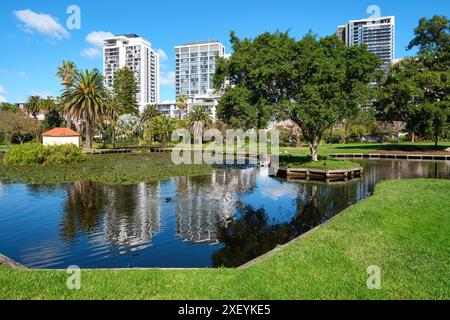 Queens Gardens, un parc situé à East Perth avec un lac, des arbres ornementaux et des immeubles d'appartements en arrière-plan, Australie occidentale. Banque D'Images