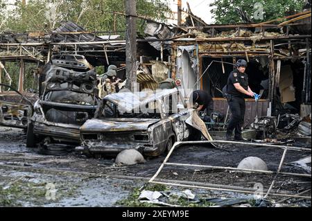 VILNIANSK, UKRAINE - le 29 JUIN 2024 - des voitures incendiées et un bâtiment sont photographiés lors d'un effort de riposte à l'attaque de missiles russes dans le centre de Vilniansk, dans la région de Zaporizhzhia, dans le sud de l'Ukraine. La Russie a lancé des fusées dans le centre de Vilniansk, une ville proche de la ligne de front dans la région de Zaporizhzhia, à 17h40 heure locale le samedi 29 juin. L'attaque a tué sept personnes, dont trois enfants. Trente-six personnes ont été blessées, dont neuf enfants. Banque D'Images