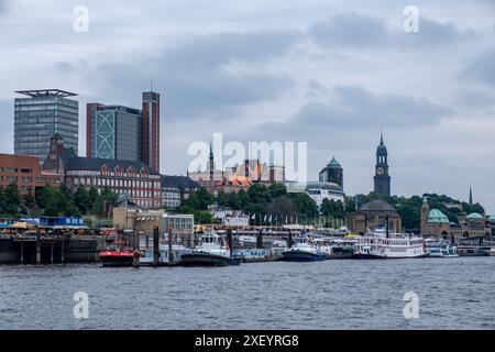 Hamburg, Germany - 05 25 2024 : vue depuis l'eau des navires amarrés à la Hamburg Landungsbrücken et les maisons à Hamburg sont réunies Pauli dans le backgroun Banque D'Images