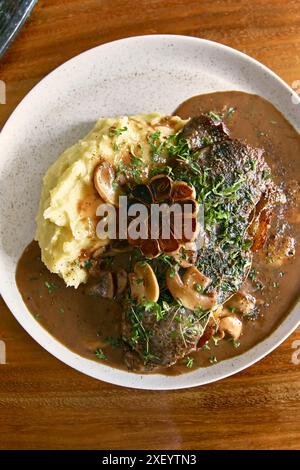 Steaks Striplion avec sauce au vin rouge sur une table en bois Banque D'Images