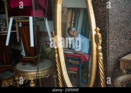 Alexandrie, Égypte. 26 juin 2024. Un vieil homme dort dans un magasin de meubles pendant la chaleur estivale d'Alexandrie, en Egypte. (Crédit image : © John Wreford/SOPA images via ZUMA Press Wire) USAGE ÉDITORIAL SEULEMENT! Non destiné à UN USAGE commercial ! Banque D'Images