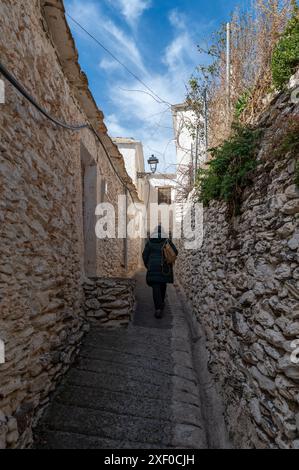 Femme vue de derrière marchant dans les rues étroites d'une ville de l'Alpujarra de Grenade (Espagne) Banque D'Images