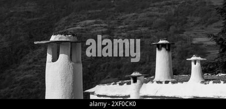 Cheminées en pierre blanche avec une pierre d'ardoise sur le dessus, typiques des maisons dans les villages de la Alpujarra (Grenade, Espagne) Banque D'Images