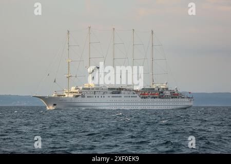 Korčula, Croatie. 30 juin 2024 : au lever du jour, le bateau de croisière à cinq mâts, l'un des plus grands voiliers du monde, navigue en mer Adriatique, approchant de l'île de Mljet. Le navire jumeau du CLUB MED 2, anciennement connu sous le nom DE CLUB MED 1, atteint la ville de Korcula, près de Dubrovnik, sur la côte dalmate. Windstar Cruises, l'énorme propriétaire de goélette staysail, a lancé une initiative pluriannuelle de plusieurs millions de dollars pour reconcevoir et rénover ses yachts de classe Wind : Wind Star, Wind Spirit & Wind Surf (navire amiral de la flotte), les travaux sur ce dernier en 2 phases fin 2024 & 2026. Crédit : Kevin Izorce/Alamy Live News Banque D'Images