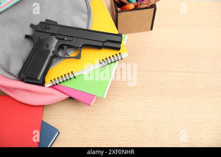 Papeterie scolaire, pistolet et sac à dos sur bureau en bois, vue au-dessus. Espace pour le texte Banque D'Images