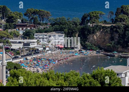 Ulcinj, Monténégro. 29 juin 2024. Un minaret de la mosquée de la vieille ville d'Ulcinj est visible à l'extrême gauche de la photo, tandis que les gens profitent du soleil et se rafraîchissent sur la petite plage face au château de la vieille ville à Ulcinj, Monténégro, prise le samedi 29 juin 2024. (VX photo/Vudi Xhymshiti) crédit : VX Pictures/Alamy Live News Banque D'Images