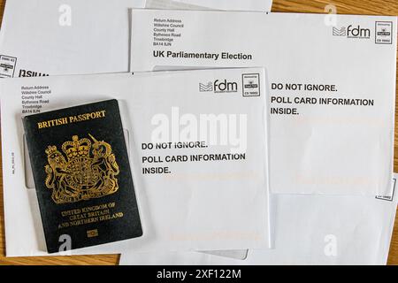 Enveloppes contenant des cartes de vote avec un passeport britannique comme pièce d'identité permettant aux citoyens de voter aux élections générales britanniques pour le prochain gouvernement Banque D'Images