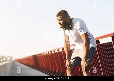 Homme se reposant après avoir couru sur Bridge Banque D'Images