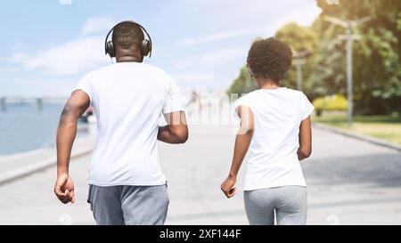 Méconnaissable Afro Couple Jogging le long River Embankment Banque D'Images