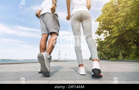 Méconnaissable Black Couple du jogging le long de Rivière, Low-Angle, vue arrière Banque D'Images