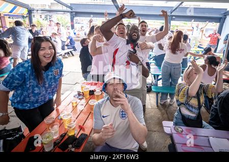 Londres, Royaume-Uni. 30 juin 2024. EURO 2024 : Angleterre vs Slovaquie. 4TheFans Fan Park à Brixton Jamm fanzone. Les supporters anglais réagissent et célèbrent alors que le milieu de terrain Jude Bellingham marque un égaliseur étonnant avec quelques secondes à gagner pour assurer à l'équipe anglaise une place en quart de finale à l'Euro 2024 après avoir battu la Slovaquie 2-1 en temps supplémentaire. Crédit : Guy Corbishley/Alamy Live News Banque D'Images