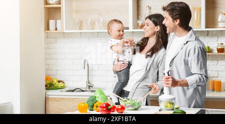 Famille heureuse préparer un repas sain dans la cuisine moderne Banque D'Images