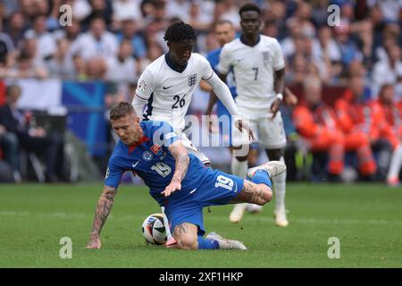 Gelsenkirchen, Allemagne. 30 juin 2024. Bukayo Saka, d’Angleterre, regarde son coéquipier Kobbie Mainoo affronter Juraj Kucka, de Slovaquie, lors de la manche 16 des Championnats d’Europe de l’UEFA à l’Arena Aufschalke, Gelsenkirchen. Le crédit photo devrait se lire : Jonathan Moscrop/Sportimage crédit : Sportimage Ltd/Alamy Live News Banque D'Images