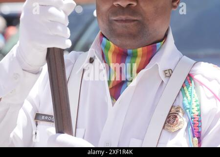 Louis, États-Unis. 30 juin 2024. Un membre de la garde d'honneur du Service des incendies de la firme Louis porte un drapeau, portant un ascot coloré lors de la défilée de la firme Louis Pride à la firme Louis le dimanche 30 juin 2024. Photo de Bill Greenblatt/UPI crédit : UPI/Alamy Live News Banque D'Images