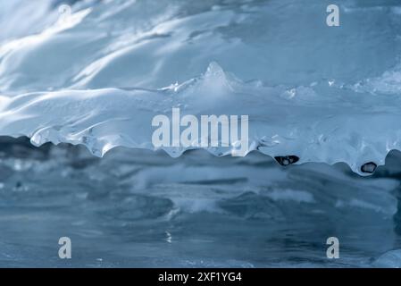 Vue imprenable sur le coucher du soleil depuis un lac gelé en hiver pris en Colombie-Britannique, Canada avec des formations de glace uniques pour l'arrière-plan, vue de bureau. Banque D'Images