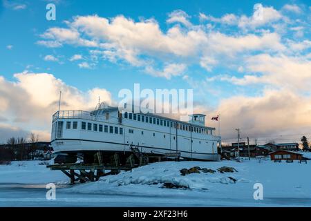 MV Tarahne située à Atlin, en Colombie-Britannique, au Canada pendant la saison hivernale au coucher du soleil. Banque D'Images
