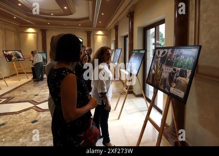 Amman. 30 juin 2024. Les gens regardent des photos sur la culture du thé de la province du Yunnan dans le sud de la Chine au Centre culturel chinois à Amman, Jordanie, le 30 juin 2024. Un événement de promotion de la culture chinoise du thé a eu lieu dimanche ici dans la capitale jordanienne avec des spectacles fascinants de musique et de danse et des costumes ethniques sur l'exposition mettant en valeur le caractère distinctif de la province du Yunnan, dans le sud de la Chine. Crédit : Mohammad Abu Ghosh/Xinhua/Alamy Live News Banque D'Images