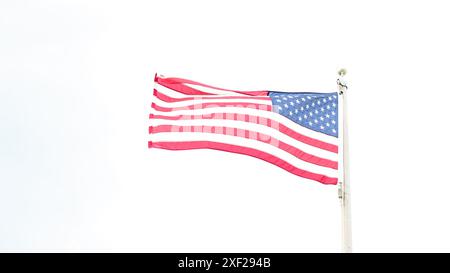 Magnifique drapeau américain agitant au vent, avec des couleurs vives rouge blanc et bleu sur le ciel bleu, avec espace de copie. Banque D'Images