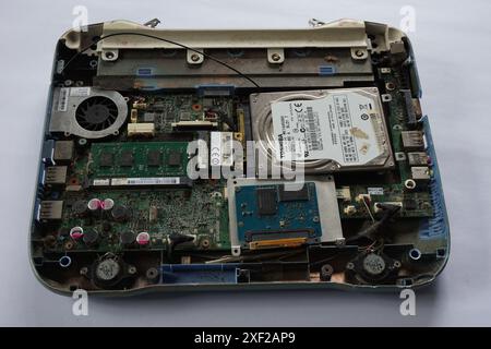 Terengganu, Malaisie - 14 juillet 2024 : démontage en gros plan d'un vieil ordinateur portable sur fond isolé. Composant d'ordinateur portable tel que la carte mère, le chipset et la RAM Banque D'Images