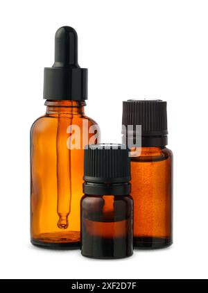 Trois bouteilles en verre ambré avec Dropper Tops sur fond blanc Banque D'Images
