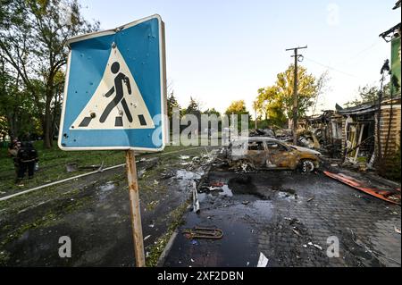 Non exclusif : VILNIANSK, UKRAINE - 29 JUIN 2024 - le panneau de passage pour piétons est vu près de voitures détruites par l'attaque de missiles russes dans le centre Banque D'Images