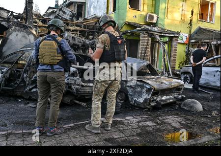 Non exclusif : VILNIANSK, UKRAINE - 29 JUIN 2024 - des experts criminels examinent des voitures détruites par la frappe de missiles russes dans le centre de Vilniansk, Zapori Banque D'Images