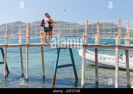 Zakynthos, Grèce - 17 août 2016 : un jeune couple adulte prend selfie au pont en bois à Agios Sostis ou à l'île de Cameo par une journée d'été ensoleillée Banque D'Images